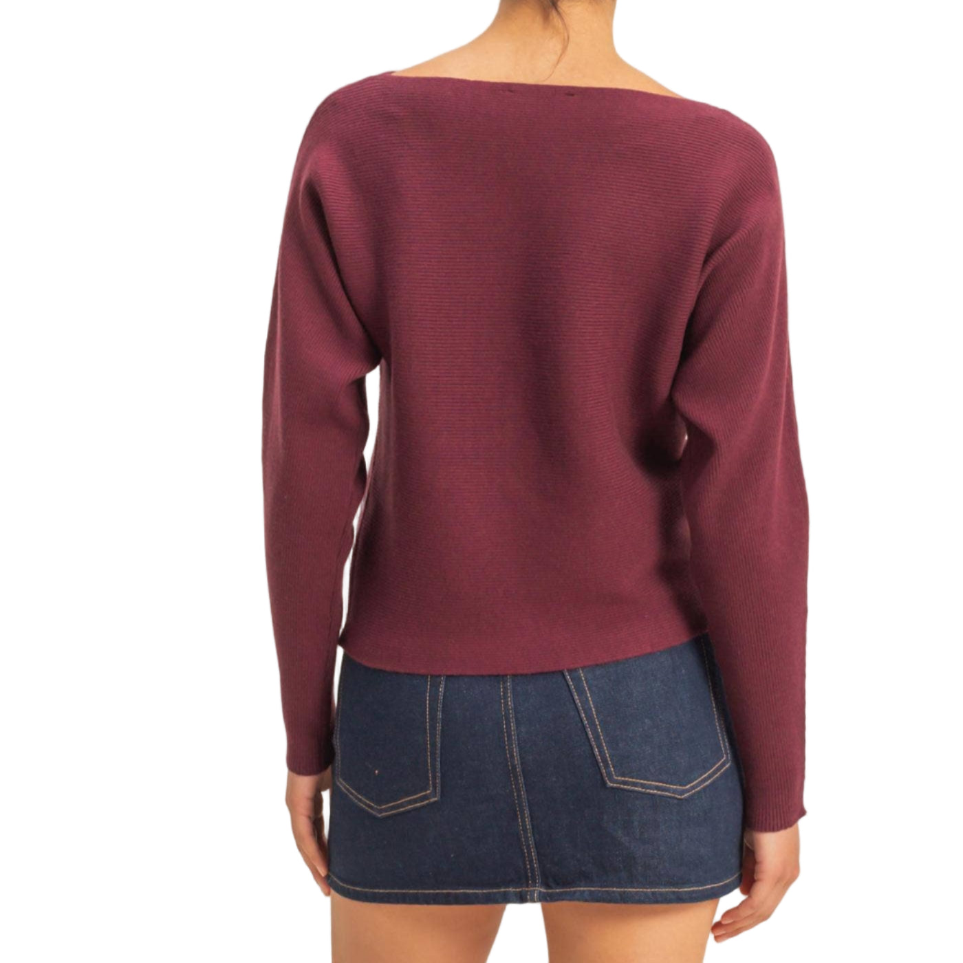 Person wearing a burgundy sweater and denim skirt on a beige background