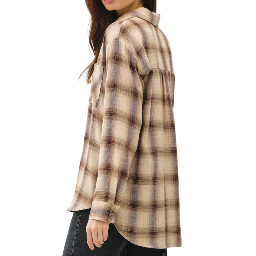 Woman wearing a plaid shirt and dark jeans on a white background