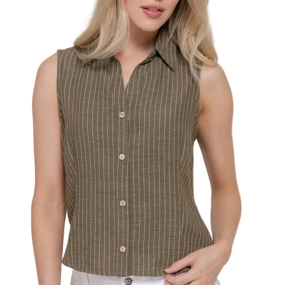 Woman wearing a sleeveless brown striped shirt with white pants on a plain background