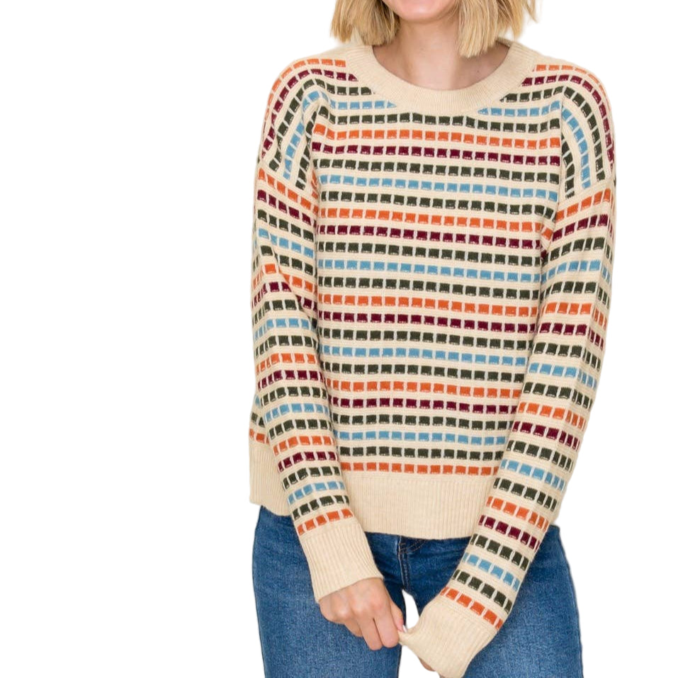 Woman wearing a colorful striped sweater on a plain background