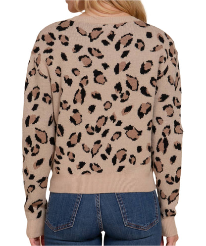 Woman wearing a beige sweater with a leopard print pattern on a beige background