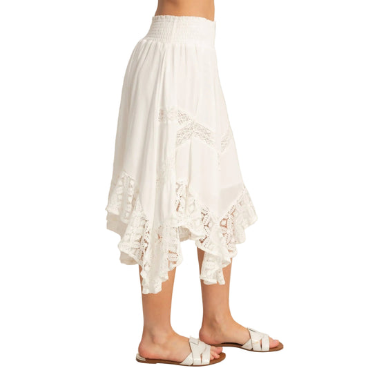 White lace skirt worn by a person on a plain background