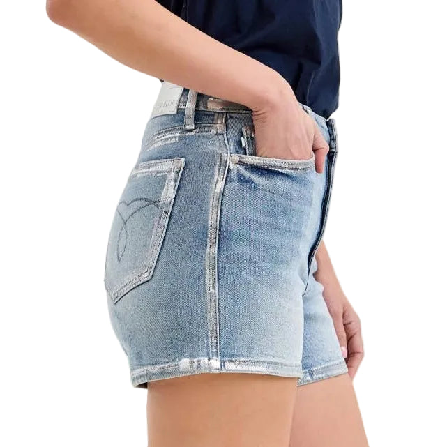 Denim shorts worn by a person on a plain background