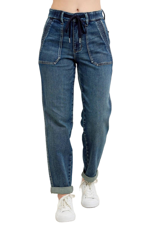 Blue jeans worn by a person on a beige background