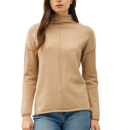 Woman wearing a beige sweater and blue jeans on a white background