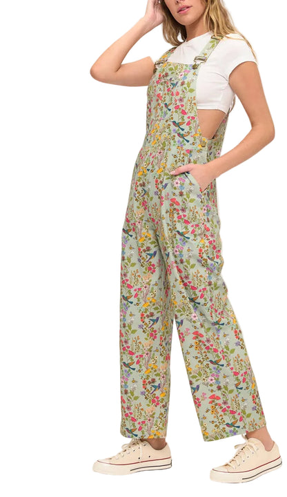 Woman wearing a floral overalls and white shirt on a white background