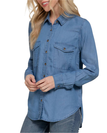 Woman wearing a blue denim shirt against a plain background