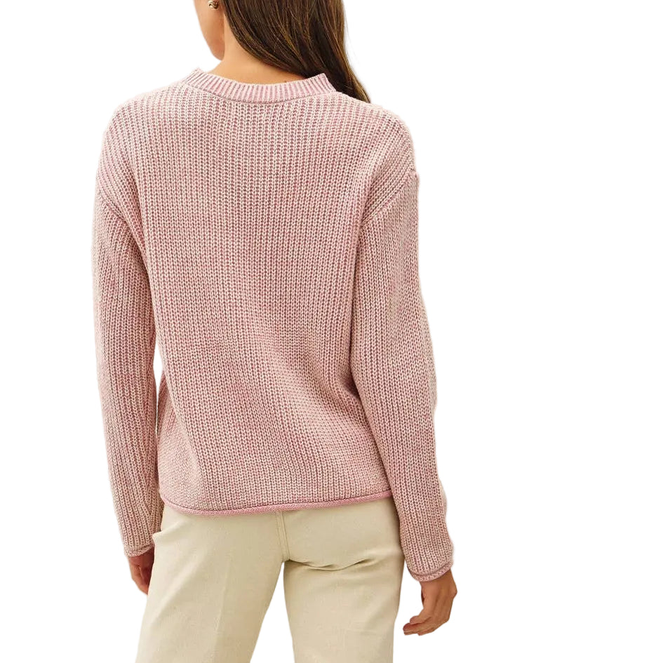 A woman shown from the back wearing a light pink ribbed knit sweater, cream-colored flared pants, and beige high-heeled sandals against a plain off-white studio background.