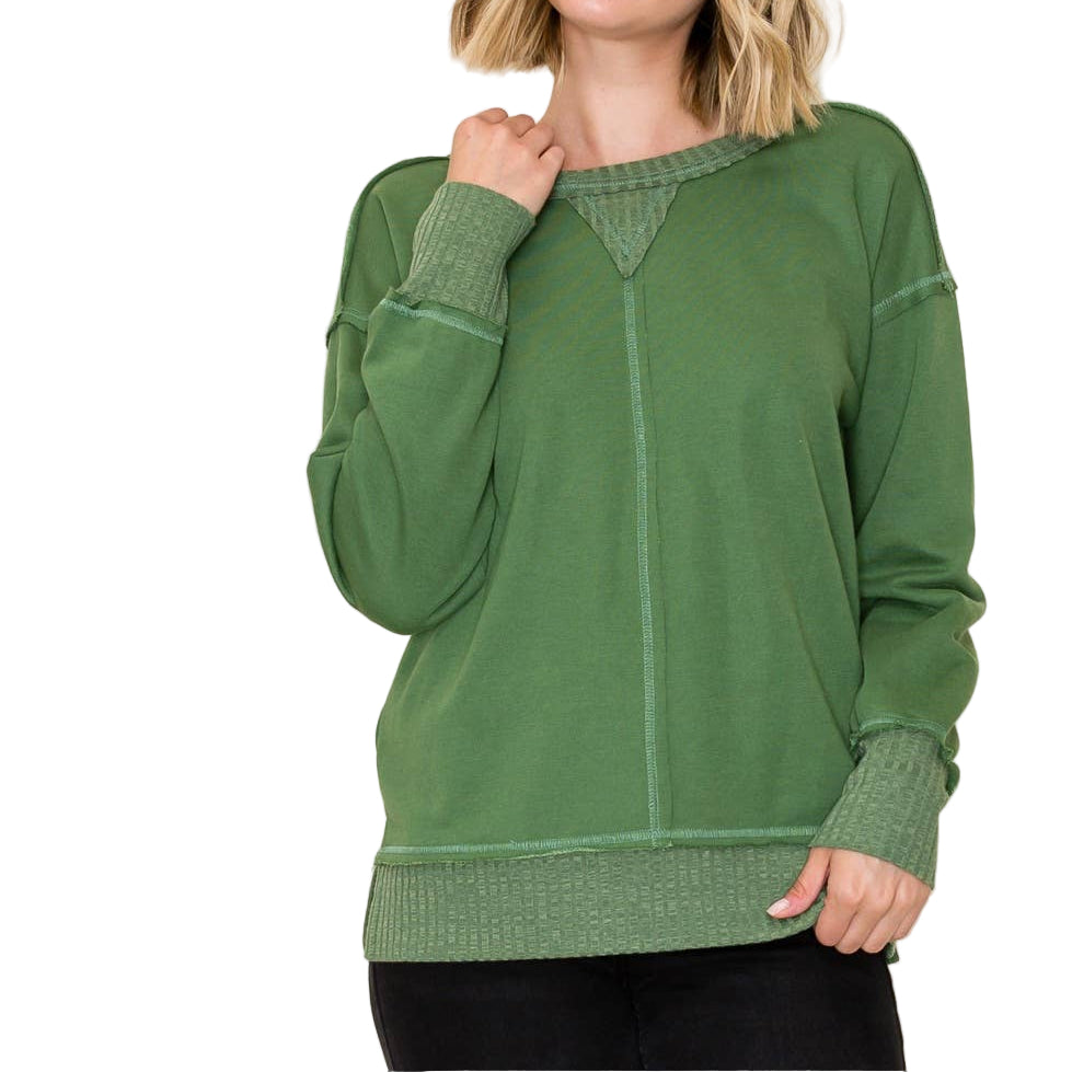 Woman wearing a green sweater against a white background