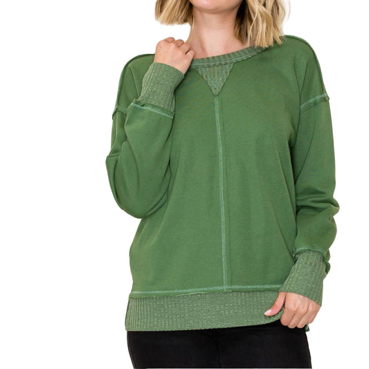 Woman wearing a green sweater against a white background