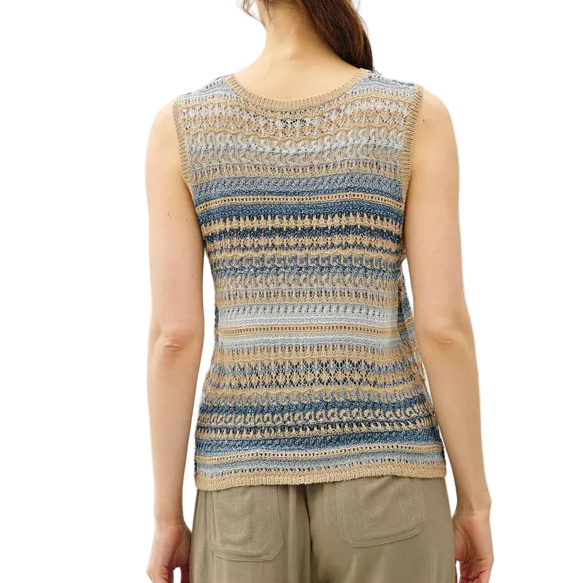 Woman wearing a sleeveless patterned top and beige pants on a white background