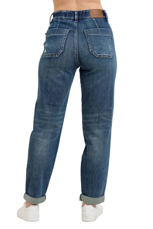 Blue jeans worn by a person on a beige background