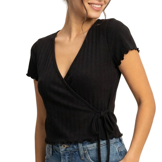 Woman wearing a black top and denim skirt on a plain background