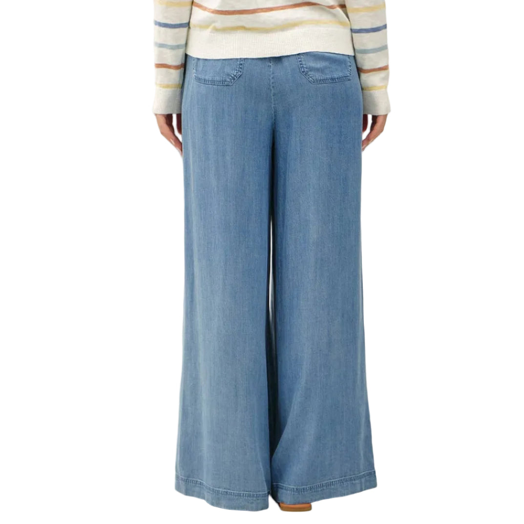 Person wearing a striped sweater and blue wide-leg pants on a white background