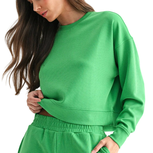 Woman wearing a green sweatshirt and shorts set on a white background