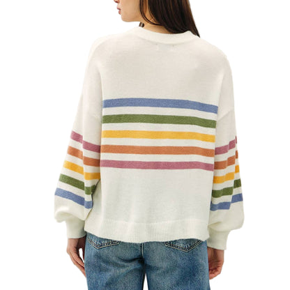 Person wearing a white sweater with rainbow stripes and blue jeans on a white background