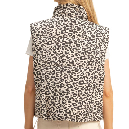 Person wearing a leopard print vest against a plain background
