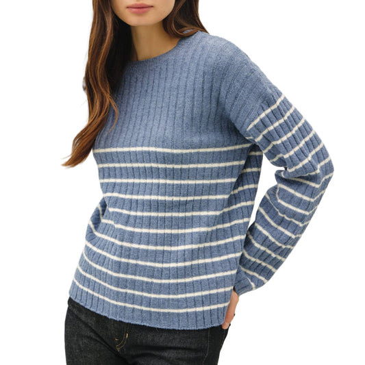 Woman wearing a blue and white striped sweater on a plain background