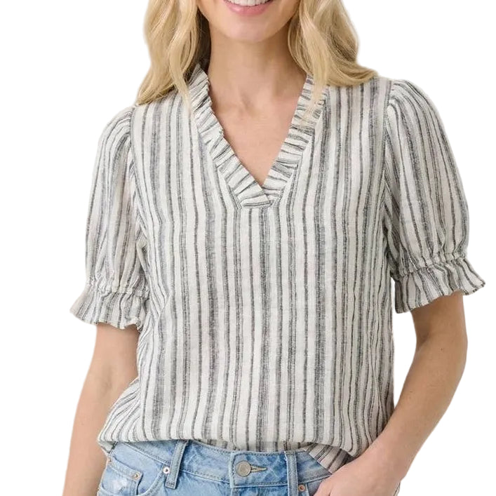 Woman wearing a striped blouse and jeans on a plain background