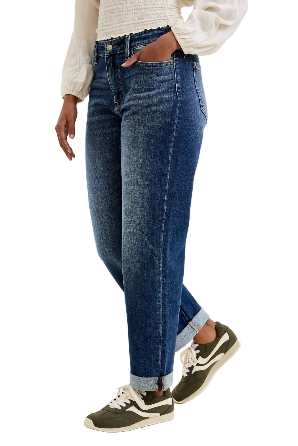 Person wearing blue jeans and white sneakers on a plain background