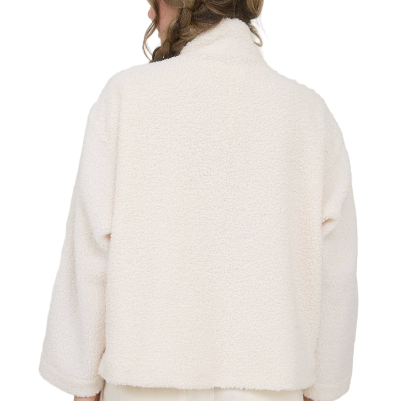 Person wearing a white coat with a Christmas tree in the background