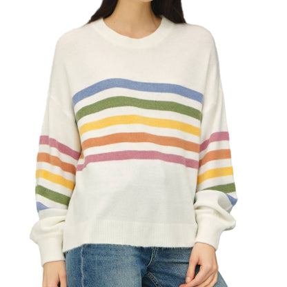 Woman wearing a white sweater with colorful horizontal stripes against a black background