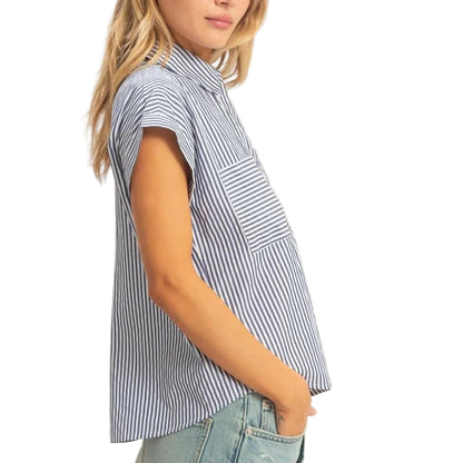 Woman wearing a striped shirt and denim shorts on a plain background