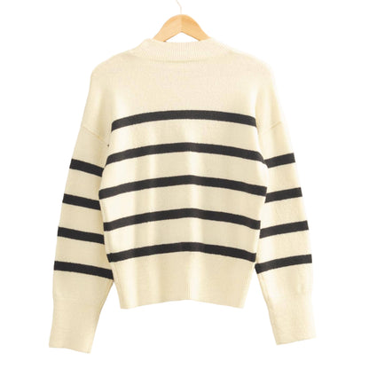 White sweater with black stripes on a hanger against a light background