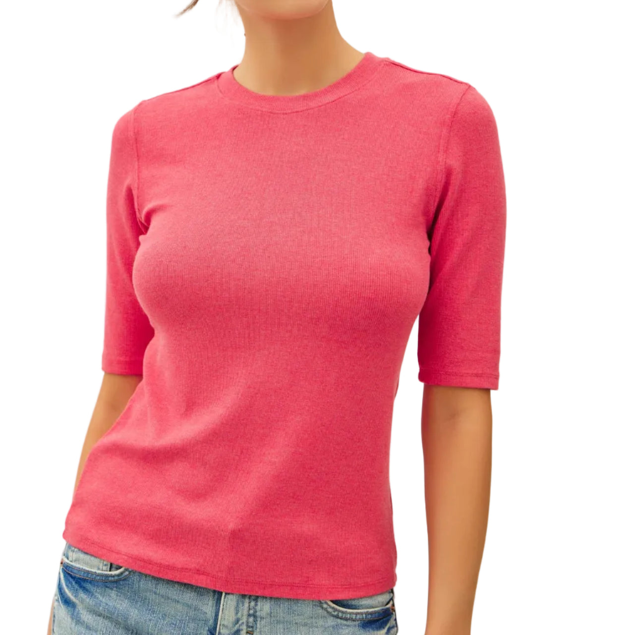 Woman wearing a pink sweater and blue jeans against a plain background