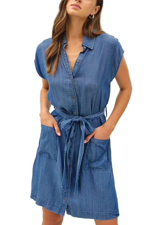 Woman wearing a blue denim dress against a plain background
