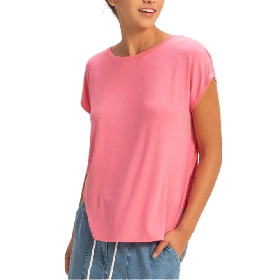 Woman wearing a pink top and blue jeans on a plain background