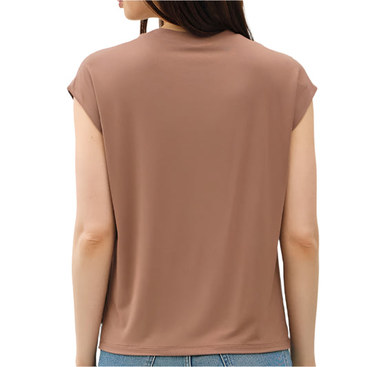 Woman wearing a brown sleeveless top and blue jeans on a white background