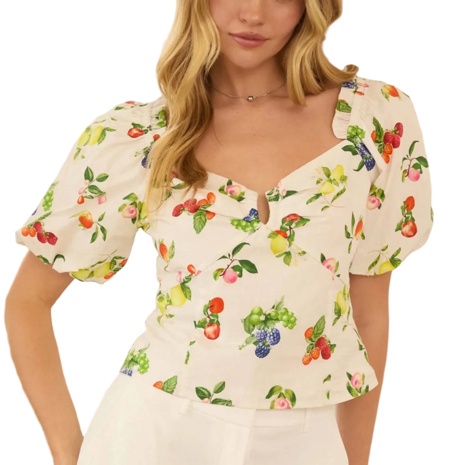 Woman wearing a floral blouse and white pants in an outdoor setting