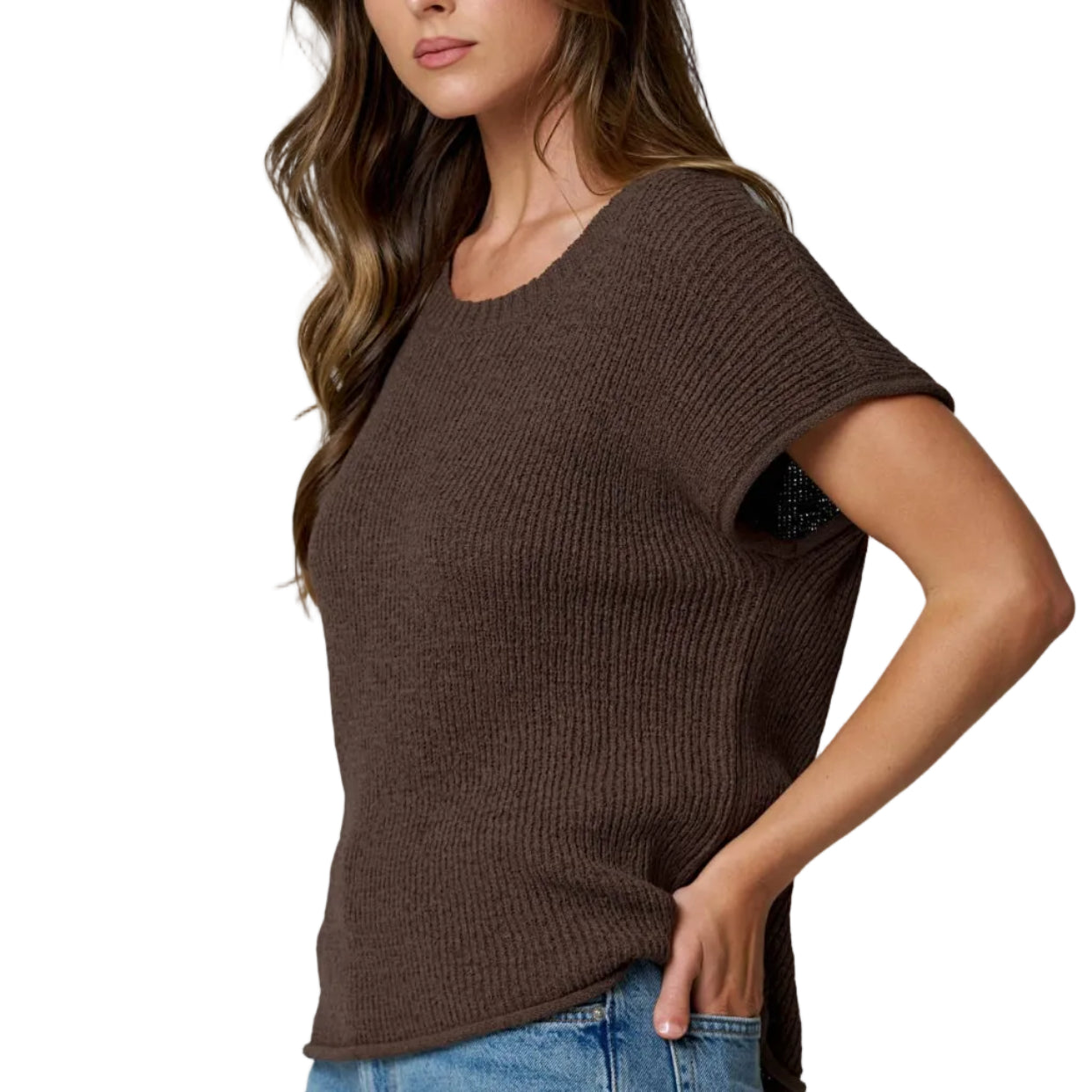Woman wearing a brown knit top and blue jeans against a light gray background