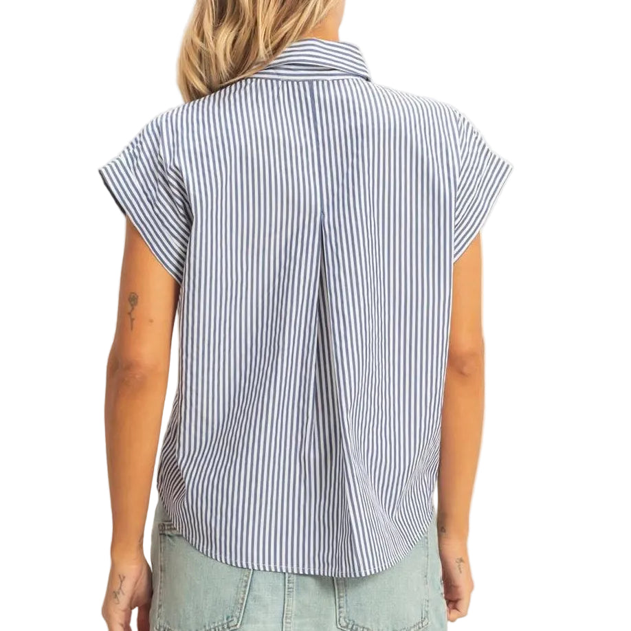 Woman wearing a blue striped shirt and denim skirt on a plain background