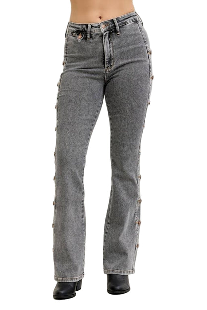 Gray jeans with decorative buttons on a plain background