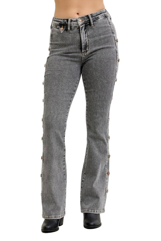 Gray jeans with decorative buttons on a plain background