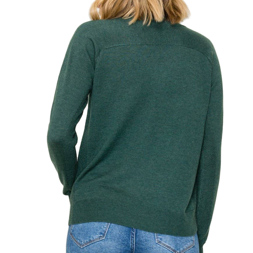 Person wearing a green sweater and blue jeans against a white background