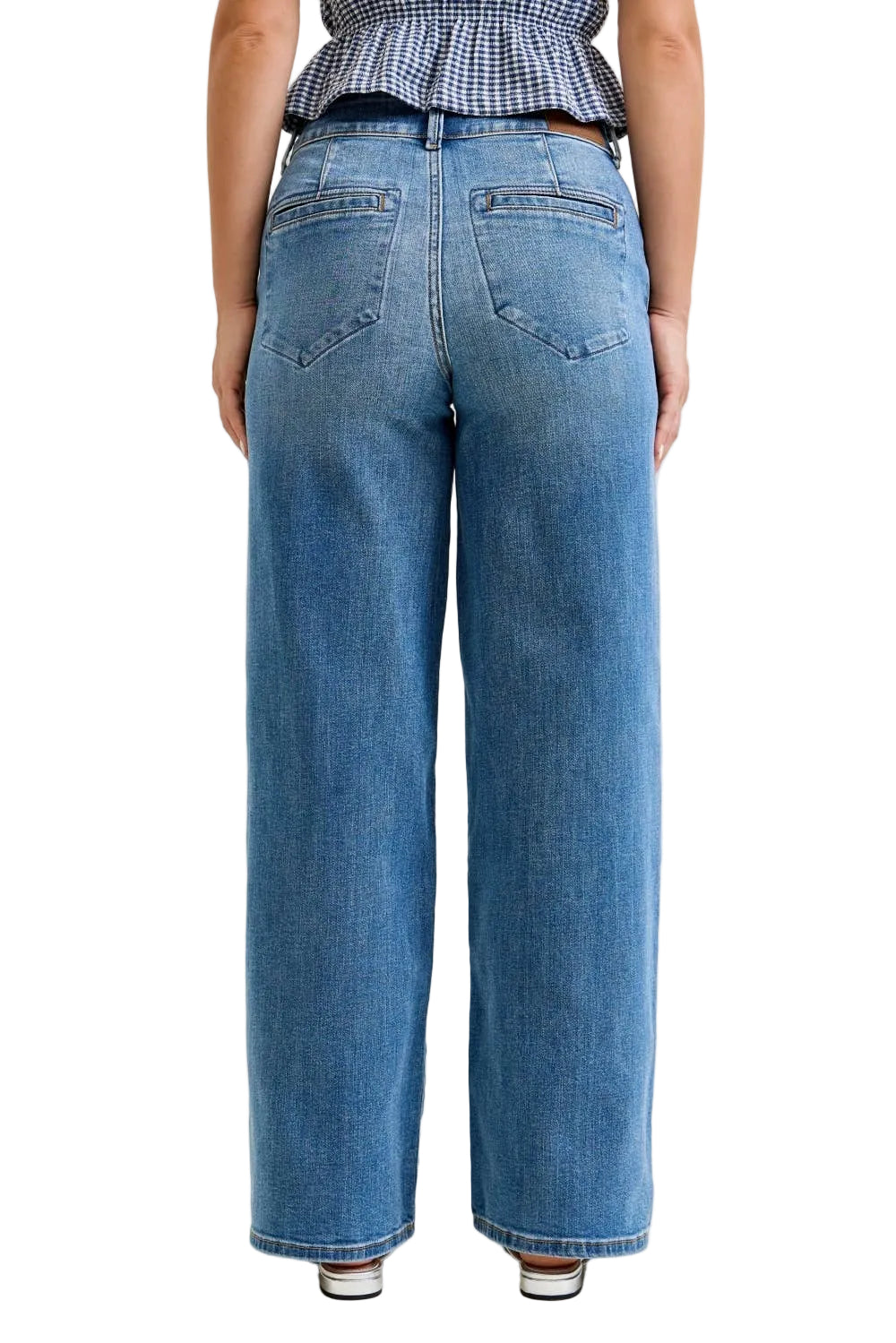 Person wearing blue jeans on a plain background