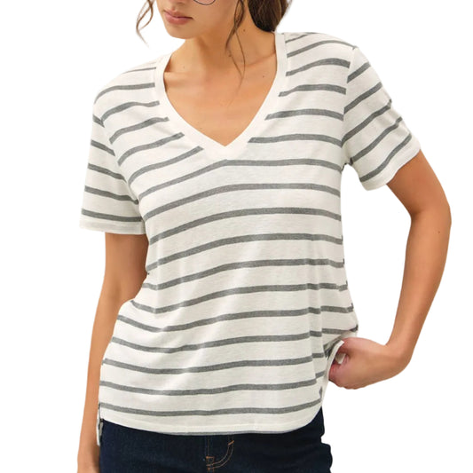 Woman wearing a striped shirt and glasses against a plain background