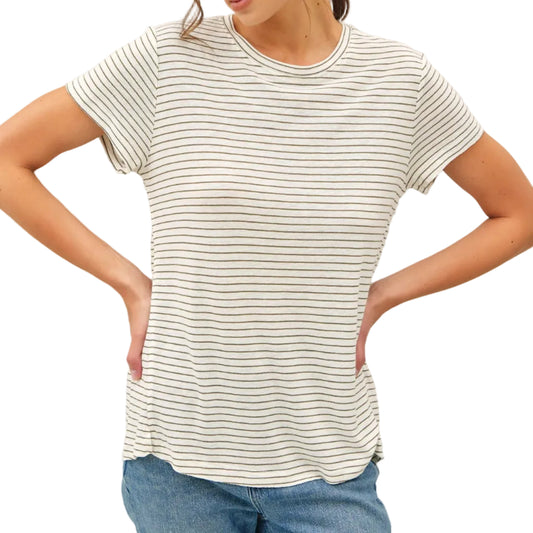 Woman wearing a striped t-shirt and blue jeans against a plain background