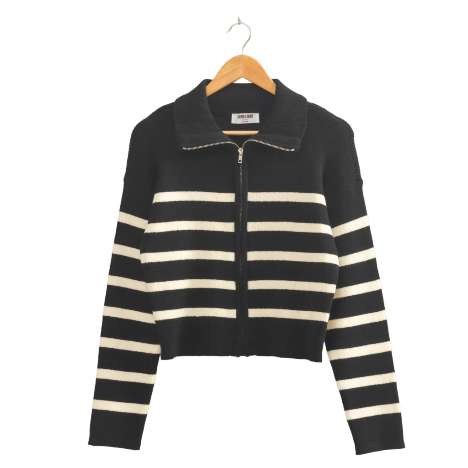 Black and white striped sweater on a hanger against a beige wall
