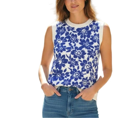 Woman wearing a blue floral top and jeans standing outdoors.