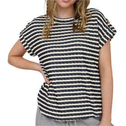 Woman wearing a black and white striped shirt against a plain background