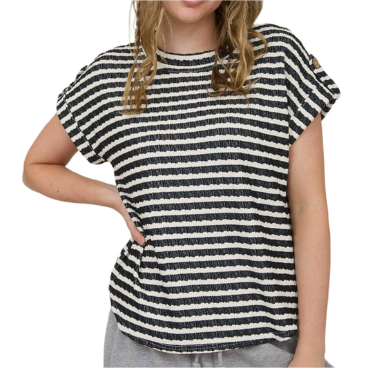 Woman wearing a black and white striped shirt against a plain background