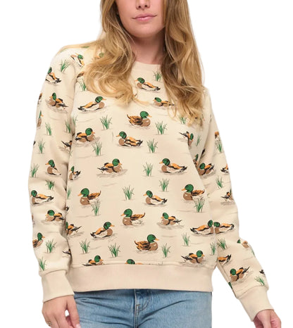 Person wearing a beige sweater with duck pattern on a plain background