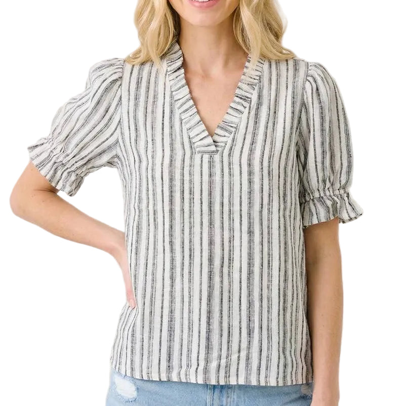 Woman wearing a striped blouse with ruffled sleeves on a beige background