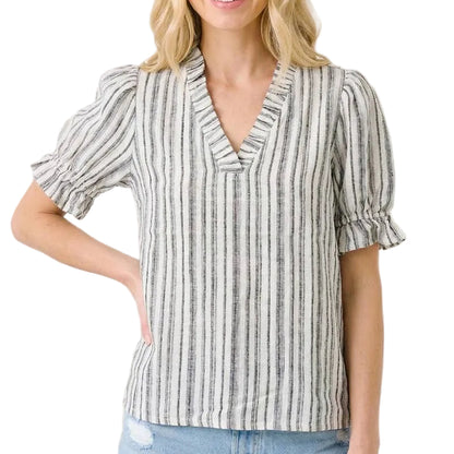 Woman wearing a striped blouse with ruffled sleeves on a beige background
