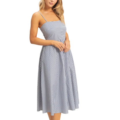 Woman wearing a blue and white striped dress on a plain background