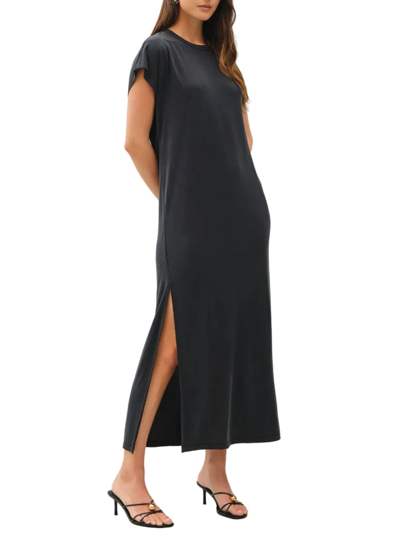 Woman wearing a black dress with a slit on a white background